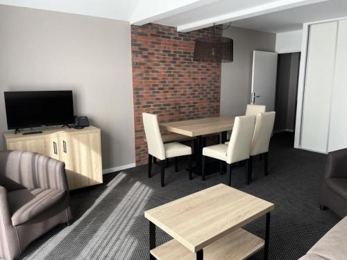 a living room with a table and chairs and a television at Résidence Le Portillo - Piscine - Studio pour 4 Personnes MAE-5323 in Gourette