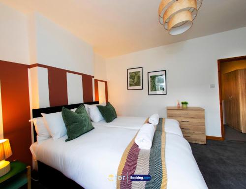 a bedroom with two beds and a dresser at Barry Vibes 3BR House by The One Retreats Short Lets & Serviced Accommodation Barry close to Barry Island in Biglis