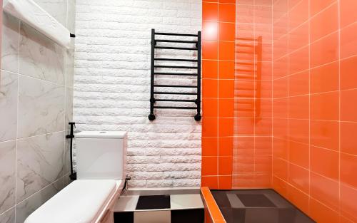 an orange and white bathroom with a toilet and a ladder at Rooms Apart Hotel by RED in Yerevan