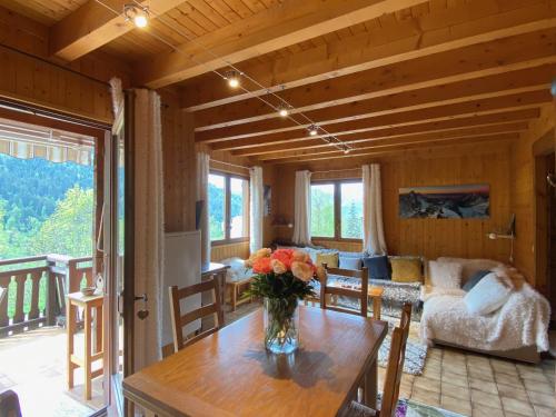 a living room with a vase of flowers on a table at Chalet aux confins à proximité du télécabine de Balme in La Clusaz