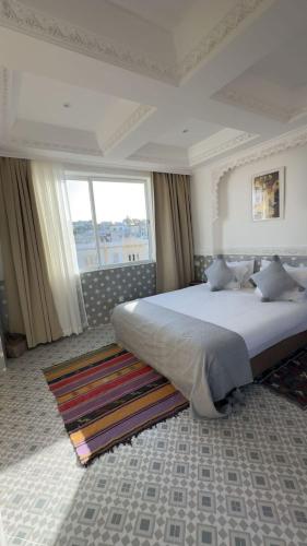 a bedroom with a large bed and a large window at RIAD TANJA by chef Moha in Tangier