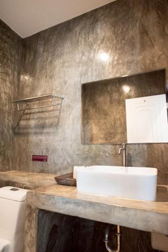 a bathroom with a sink and a toilet at The Proud Hotel in Ubon Ratchathani