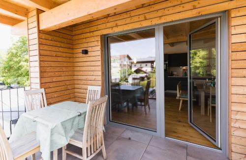 a screened in porch with a table and chairs on a patio at Seespitz 37 - Ferienwohnungen Eisendle in Seeboden