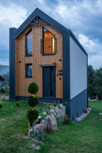 a house that is sitting in the grass at StyLove Domki 1 in Kluszkowce