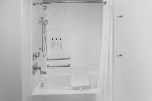 a white bathroom with a shower and a toilet at TownePlace Suites Detroit Warren in Warren