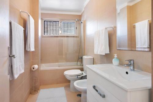 a bathroom with a sink and a toilet and a shower at Frente ao Mar in Monte Gordo