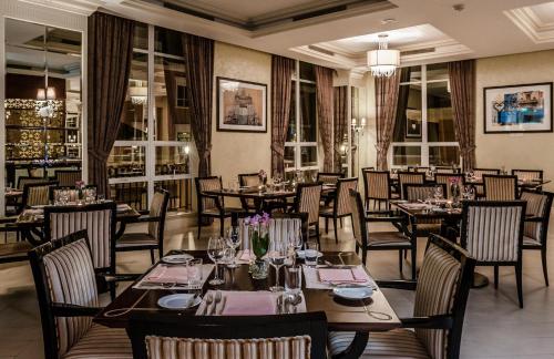 a dining room with tables and chairs and windows at Villa Rosa Kempinski in Nairobi
