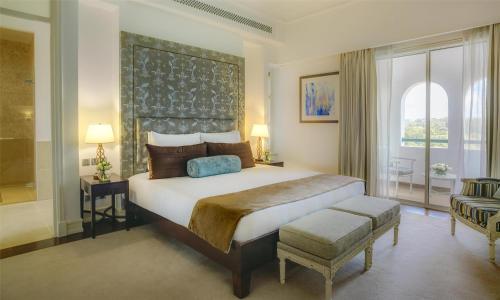 a bedroom with a large bed and a large window at Villa Rosa Kempinski in Nairobi