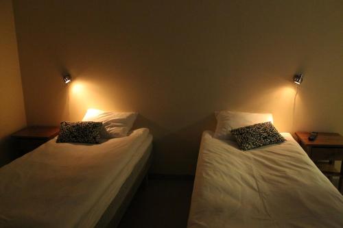 two beds in a room with lights on the wall at Stationshusets Hotell och Café in Köping