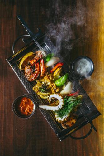 a tray of food with meat and vegetables on a table at Villa Rosa Kempinski in Nairobi
