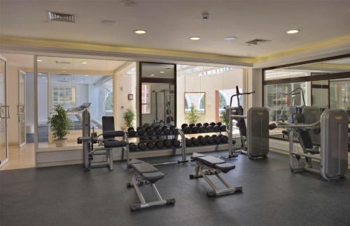 a gym with treadmills and exercise equipment and mirrors at Villa Rosa Kempinski in Nairobi