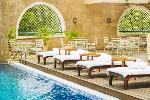 a pool with tables and chairs next to a swimming pool at Villa Rosa Kempinski in Nairobi