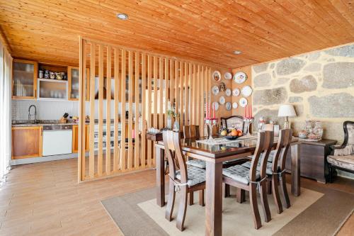 a kitchen and dining room with a table and chairs at Casa de Campo do Telhado Caldelas in Caldelas