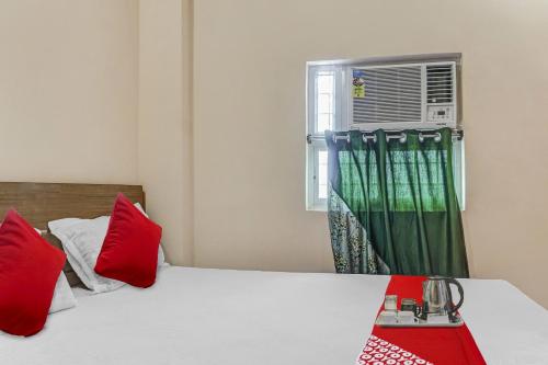a bedroom with two beds with red pillows and a window at Hotel O Green Palace in Gulzārbāgh