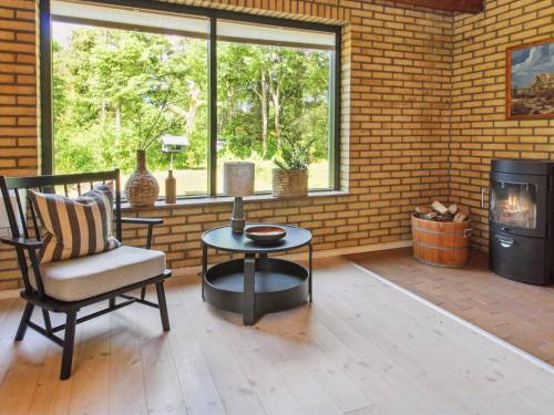 a patio with a chair and a table and a fireplace at Holiday Home Kersta - 3-3km from the sea by Interhome in Kongsmark