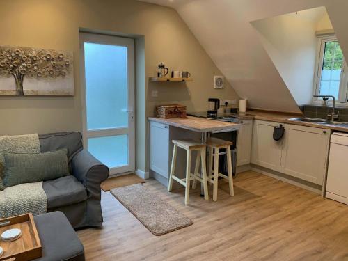 a living room with a couch and a kitchen at The Frog Langport Luxury in Langport