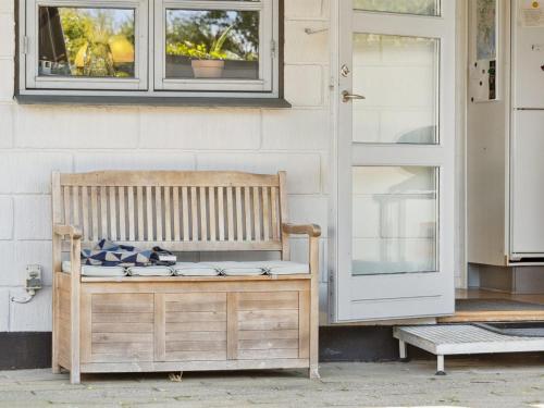 a wooden bench sitting in front of a door at Holiday Home Eikka - 100m from the sea by Interhome in Knebel