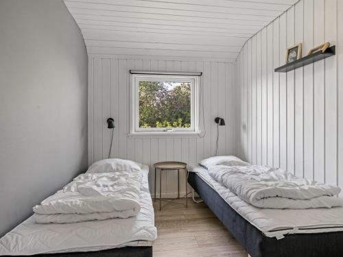 two beds in a room with a window at Holiday Home Persa - from the sea by Interhome in Hals