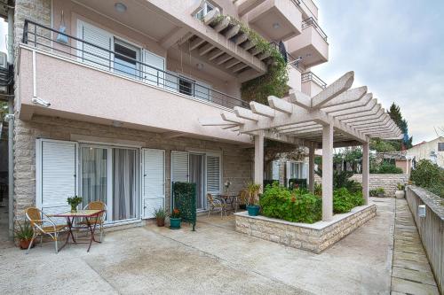 a patio with a table and chairs on a house at Petrovac Holiday Apartments in Petrovac na Moru