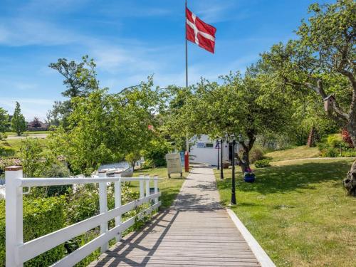 a white fence and a wooden walkway with a canadian flag at Apartment Gilbert - 500m from the sea by Interhome in Sæby