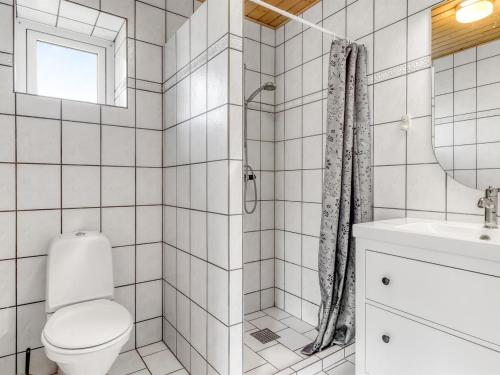 a white bathroom with a toilet and a sink at Apartment Gilbert - 500m from the sea by Interhome in Sæby