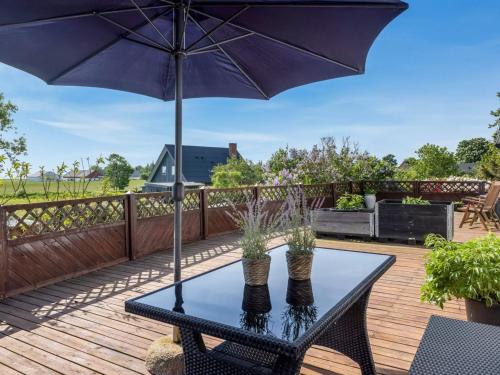 a black table with an umbrella on a deck at Apartment Veronica - 700m from the sea by Interhome in Sæby
