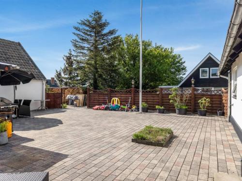 a backyard with a fence and a playground at Apartment Veronica - 700m from the sea by Interhome in Sæby