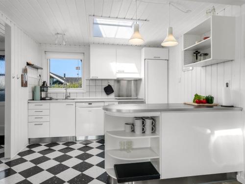 a kitchen with white cabinets and a checkered floor at Holiday Home Myrte - 300m from the sea by Interhome in Blokhus