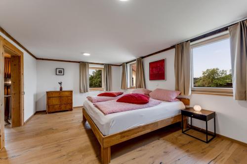 a bedroom with a bed with red pillows on it at Ferienwohnung Bergblick - stilvoll & modern im Grünen in Grünenbach