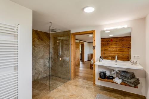 a bathroom with a sink and a shower at Ferienwohnung Bergblick - stilvoll & modern im Grünen in Grünenbach