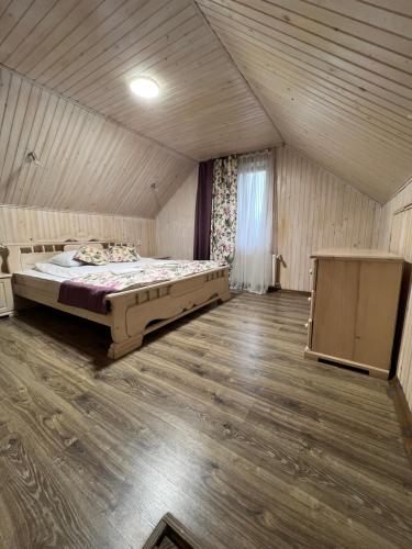 a bedroom with a bed and a wooden floor at VULYK z MEDOM in Bukovel