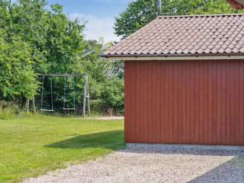 ein rotes Gebäude mit einem Fußballtor auf einem Feld in der Unterkunft Holiday Home Fritza - 500m from the sea by Interhome in Fårevejle
