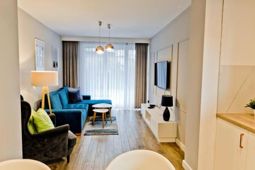 a living room with a blue couch and a table at Apartamenty Klifowa Rewal 98 in Rewal