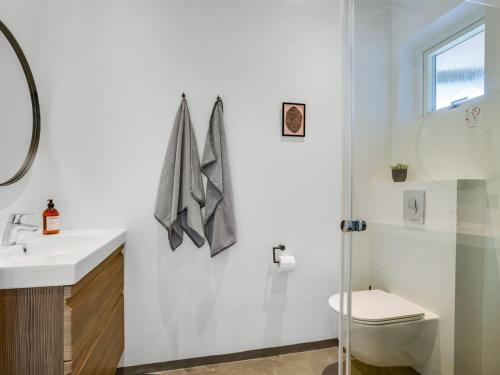 a white bathroom with a toilet and a sink at Holiday Home Melina - 900m to the fjord by Interhome in Farsø
