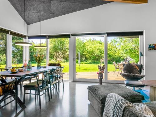 a dining room with a table and chairs and sliding glass doors at Holiday Home Melina - 900m to the fjord by Interhome in Farsø