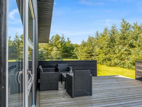 a patio with chairs and tables on a deck at Holiday Home Ema - 1-9km from the sea by Interhome in Saltum