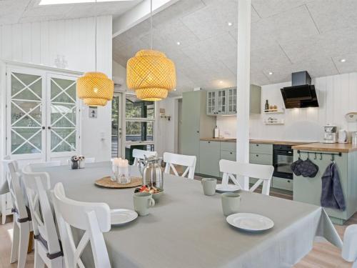 a kitchen and dining room with a table and chairs at Holiday Home Ema - 1-9km from the sea by Interhome in Saltum