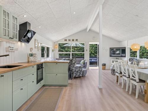 a kitchen and dining room with a table and chairs at Holiday Home Ema - 1-9km from the sea by Interhome in Saltum