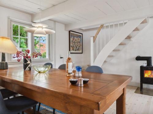 a dining room with a wooden table and a fireplace at Holiday Home Øde - 100m from the sea by Interhome in Svaneke
