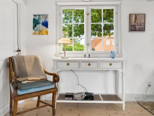 a white desk with a chair and a window at Holiday Home Øde - 100m from the sea by Interhome in Svaneke