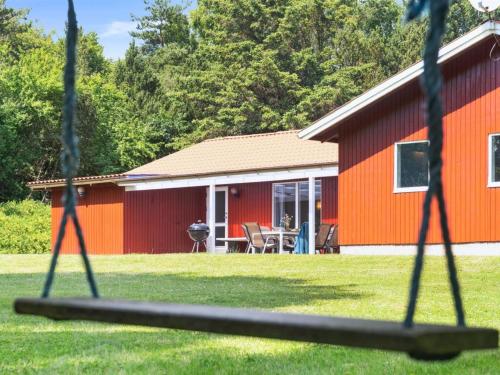 ein rotes Gebäude mit einem Tisch und Stühlen im Hof in der Unterkunft Holiday Home Paulus - 375m from the sea by Interhome in Fårevejle