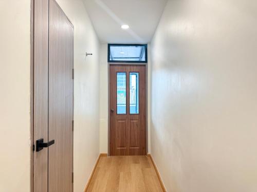 a hallway with a wooden door and a window at 豪华市中心联排别墅-暹罗百丽宫-siam in Pratunam
