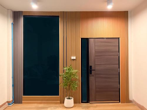 a wooden door with a plant in front of it at 豪华市中心联排别墅-暹罗百丽宫-siam in Pratunam