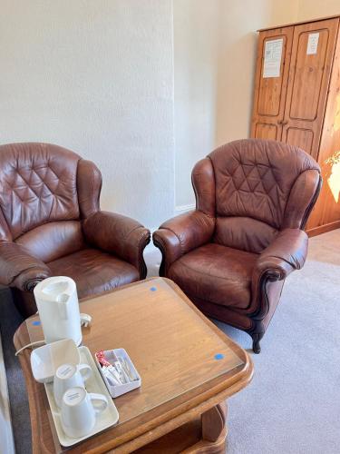 two leather chairs and a coffee table in a room at Kendal Hotel in Blackpool