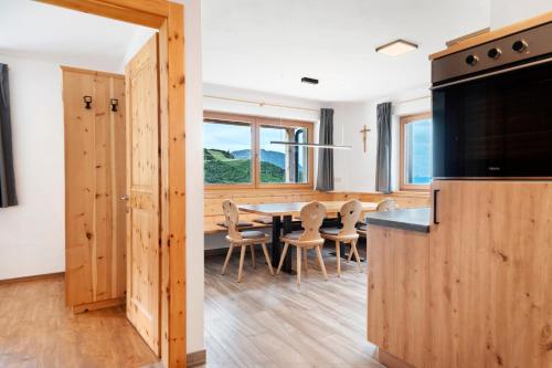 Una cocina y un comedor con mesa y sillas. en Almhaus Morgenrast, en Sarentino