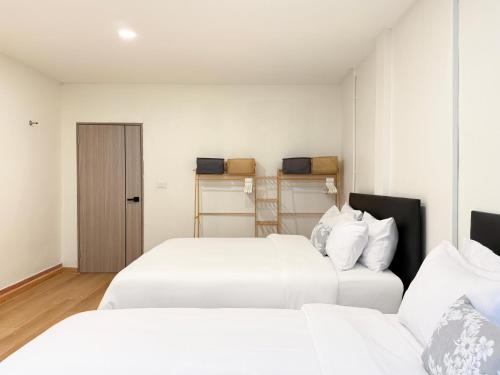 two beds in a room with white sheets at 豪华市中心联排别墅-暹罗百丽宫-siam in Pratunam
