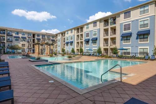 an apartment complex with a swimming pool in a courtyard at Frisco Vibes With Pool Gym and Elegant 1BR Apart in Frisco
