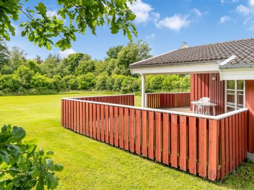 a red fence in front of a house with a yard at Holiday Home Bruna - 300m from the sea by Interhome in Jerup