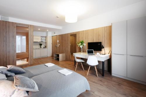 a bedroom with a bed and a desk with a computer at Wolska Residence in Warsaw