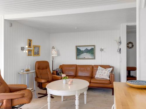 a living room with a couch and chairs and a table at Holiday Home Reima - 50m from the sea by Interhome in Sæby